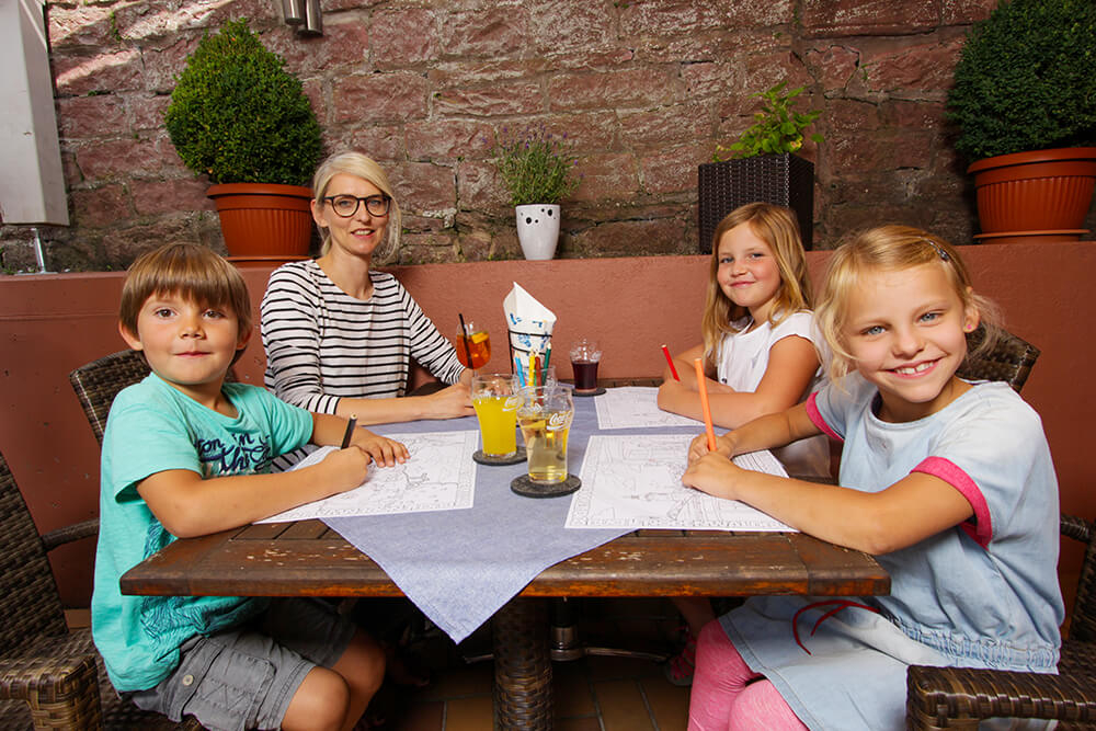 Familie mit Kindern sitzen am Tisch